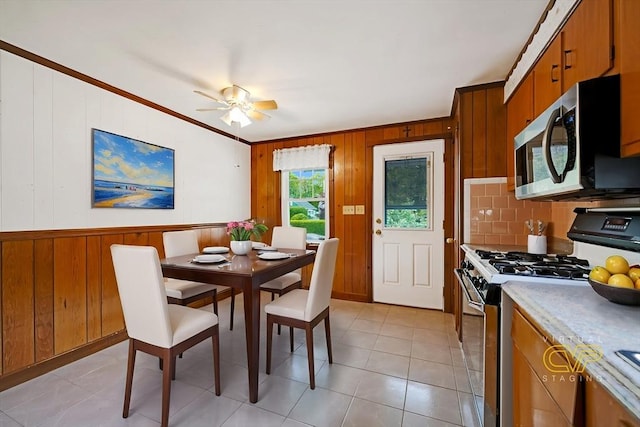 209 Sharp St, Dartmouth, MA 02747 - dining area with wood walls, crown molding, ceiling fan, and light tile patterned flooring