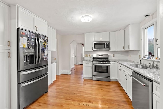 11 Douglas Ave, Burlington, MA 01803 - kitchen with stainless steel appliances, a sink, white cabinets, and light wood finished floors