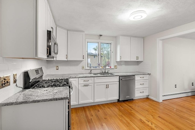 11 Douglas Ave, Burlington, MA 01803 - kitchen featuring appliances with stainless steel finishes, a sink, baseboard heating, light wood finished floors, and light stone counters