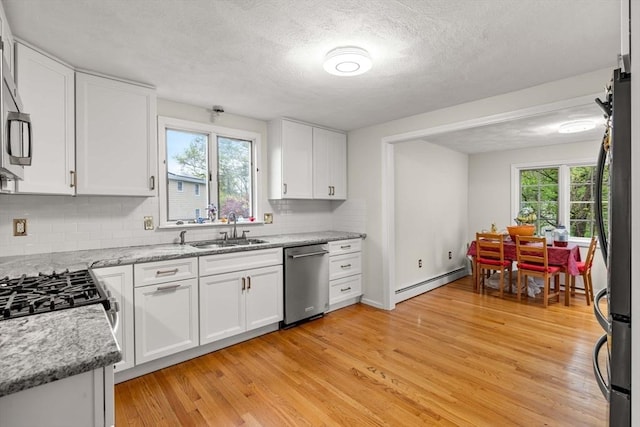 11 Douglas Ave, Burlington, MA 01803 - kitchen featuring appliances with stainless steel finishes, a sink, baseboard heating, tasteful backsplash, and light wood-style flooring