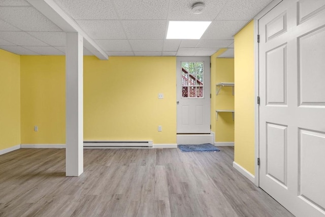 11 Douglas Ave, Burlington, MA 01803 - basement featuring a paneled ceiling, baseboard heating, light wood-style flooring, and baseboards
