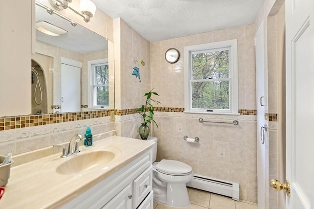 11 Douglas Ave, Burlington, MA 01803 - bathroom featuring baseboard heating, tile walls, toilet, tile patterned floors, and vanity
