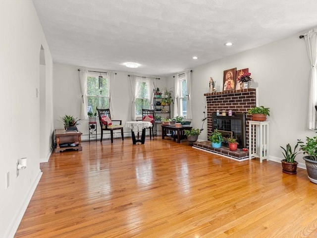11 Douglas Ave, Burlington, MA 01803 - living room with light wood finished floors, arched walkways, recessed lighting, baseboards, and a fireplace