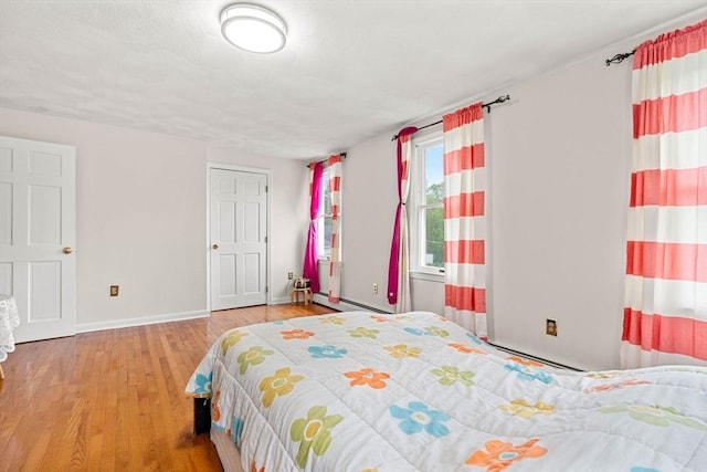 11 Douglas Ave, Burlington, MA 01803 - bedroom with baseboard heating, baseboards, wood finished floors, and a baseboard radiator