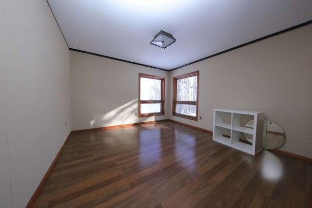 spare room featuring crown molding and dark hardwood / wood-style floors