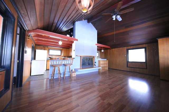 unfurnished living room with ceiling fan, wooden ceiling, dark hardwood / wood-style flooring, and wood walls