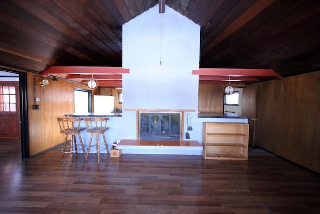 unfurnished living room with vaulted ceiling with beams, dark hardwood / wood-style flooring, wood ceiling, and wooden walls