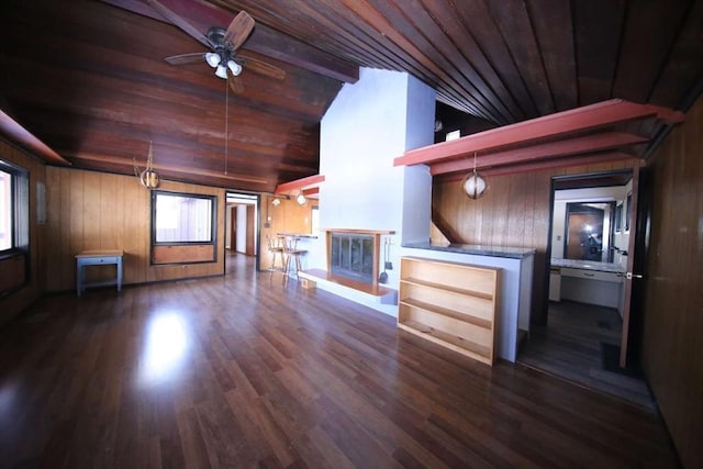 unfurnished living room featuring dark hardwood / wood-style flooring, lofted ceiling with beams, wood ceiling, and wooden walls