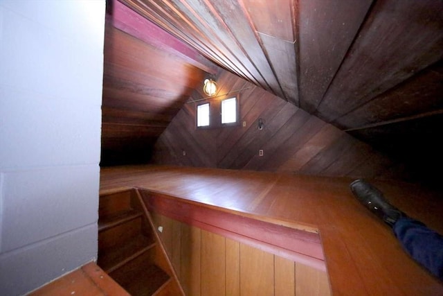 additional living space featuring lofted ceiling, wood ceiling, and wood walls