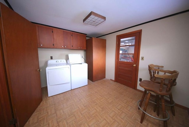 laundry room with cabinets, light parquet flooring, and washer and clothes dryer