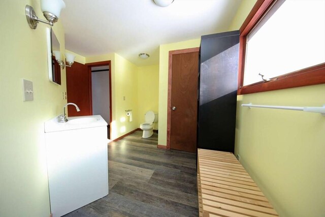 hallway featuring sink, dark hardwood / wood-style flooring, and an inviting chandelier