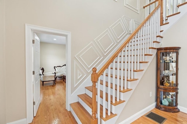 staircase with hardwood / wood-style floors