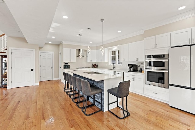 kitchen featuring white cabinetry, white refrigerator, a kitchen breakfast bar, double oven, and pendant lighting