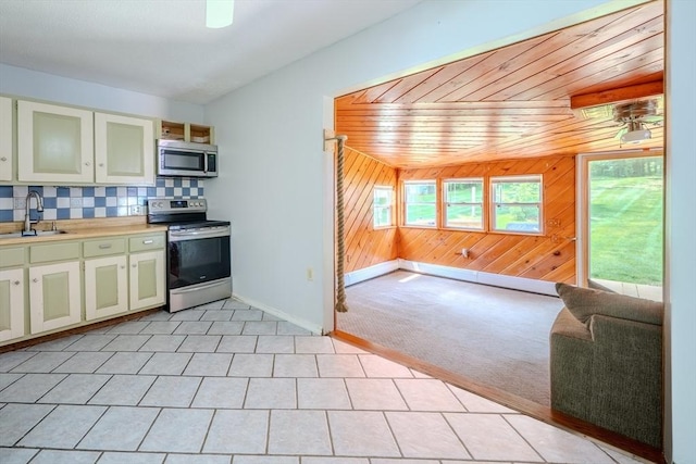 71 Webber Rd, Brookfield, MA 01506 - kitchen with stainless steel appliances, wooden walls, decorative backsplash, light countertops, and open floor plan