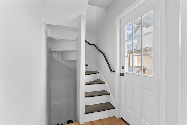 staircase with a healthy amount of sunlight and hardwood / wood-style floors