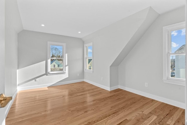 additional living space featuring lofted ceiling and light wood-type flooring