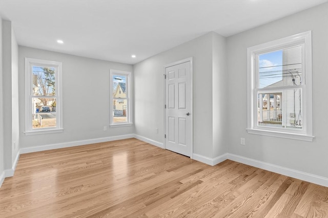 unfurnished bedroom featuring multiple windows and light hardwood / wood-style flooring