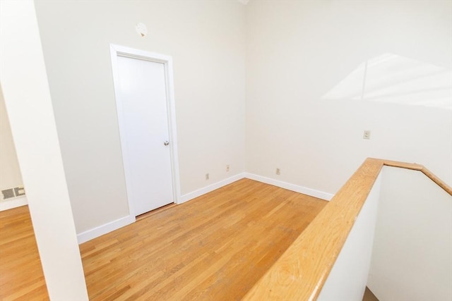 empty room with light wood-style flooring, baseboards, and visible vents