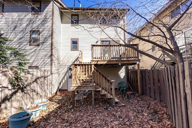 rear view of property featuring a fenced backyard, a deck, and stairs