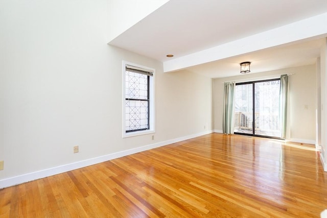 spare room with light wood-style floors and baseboards