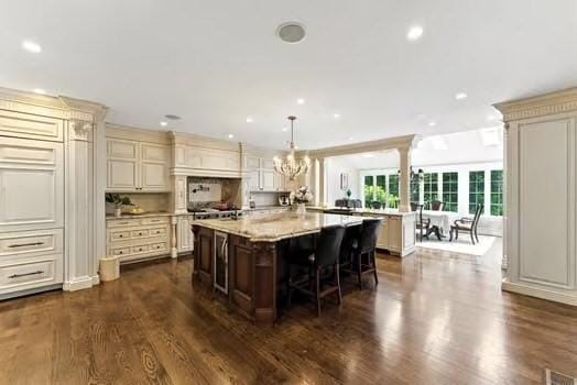56 Cart Path Rd, Weston, MA 02493 - kitchen featuring cream cabinets, a breakfast bar, dark wood-style floors, a spacious island, and recessed lighting