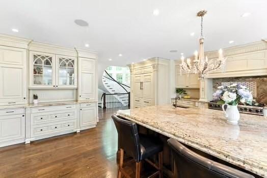 56 Cart Path Rd, Weston, MA 02493 - kitchen with light stone counters, a chandelier, dishwashing machine, glass insert cabinets, and recessed lighting