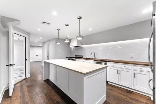 56 Cart Path Rd, Weston, MA 02493 - kitchen with a center island, white cabinets, dark wood-type flooring, pendant lighting, and recessed lighting