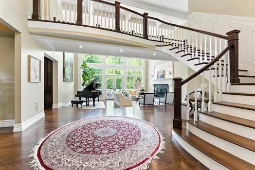 56 Cart Path Rd, Weston, MA 02493 - entryway with a fireplace, wood finished floors, stairway, and a towering ceiling