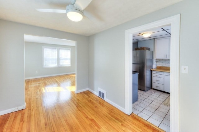 spare room with ceiling fan and light wood-type flooring