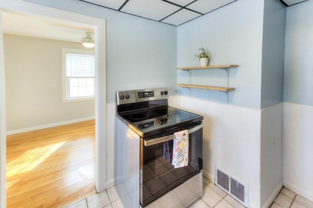 kitchen featuring a paneled ceiling, light hardwood / wood-style flooring, and electric range