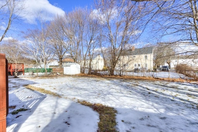 yard covered in snow featuring a storage shed