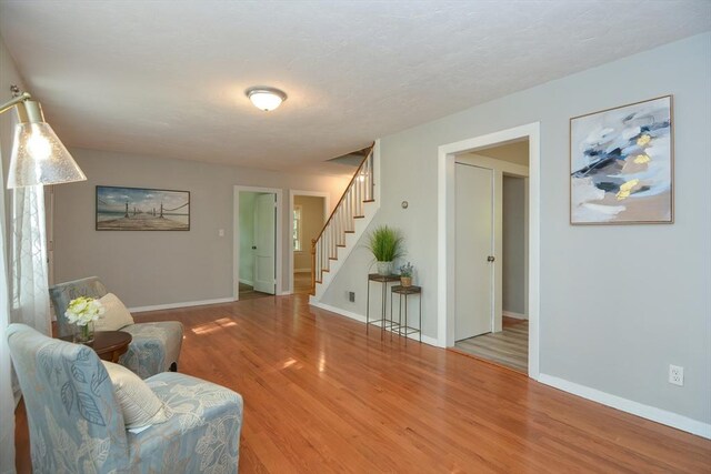 16 W St, Natick, MA 01760 - sitting room featuring stairs, wood finished floors, and baseboards
