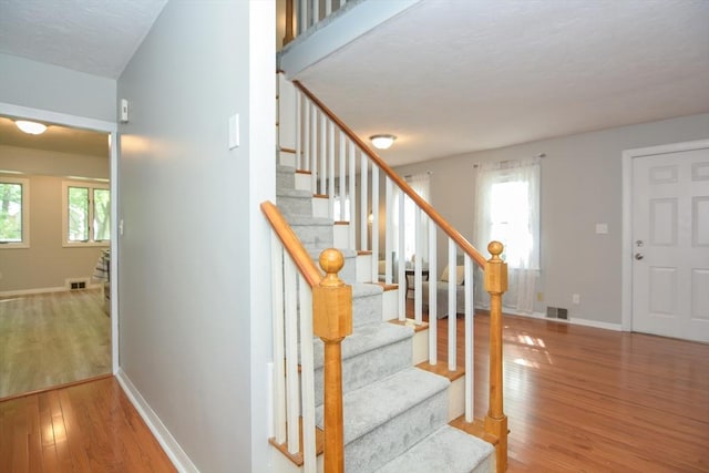 16 W St, Natick, MA 01760 - stairway featuring wood finished floors, healthy amount of natural light, and baseboards