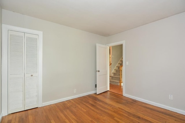16 W St, Natick, MA 01760 - unfurnished bedroom featuring baseboards, wood finished floors, and a closet