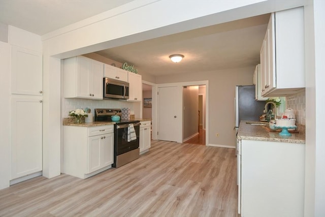 16 W St, Natick, MA 01760 - kitchen with stainless steel appliances, tasteful backsplash, light wood-type flooring, and white cabinetry