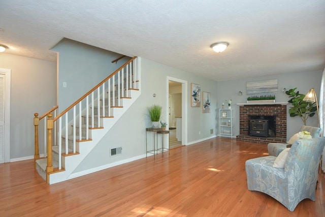 16 W St, Natick, MA 01760 - living room featuring stairs, wood finished floors, baseboards, and a textured ceiling