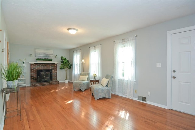 16 W St, Natick, MA 01760 - living room with wood finished floors, plenty of natural light, baseboards, and a wood stove