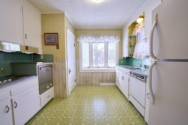 kitchen featuring crown molding, sink, white cabinets, and white appliances