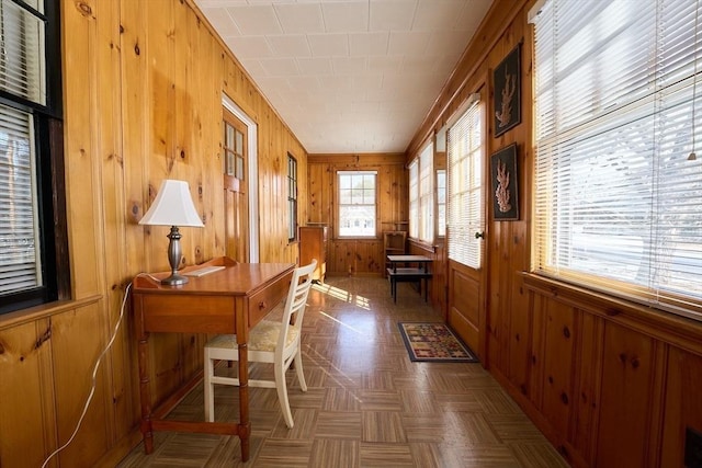 office space featuring dark parquet floors and wood walls