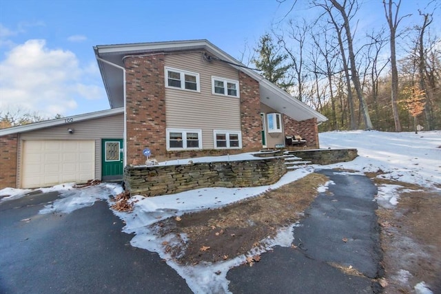 view of snow covered exterior with a garage