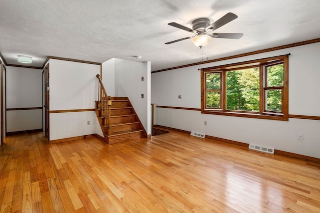 interior space featuring ornamental molding, light hardwood / wood-style floors, ceiling fan, and a textured ceiling