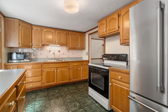 kitchen with appliances with stainless steel finishes, sink, and tasteful backsplash