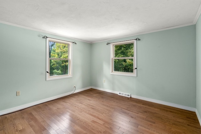 spare room with wood-type flooring and ornamental molding