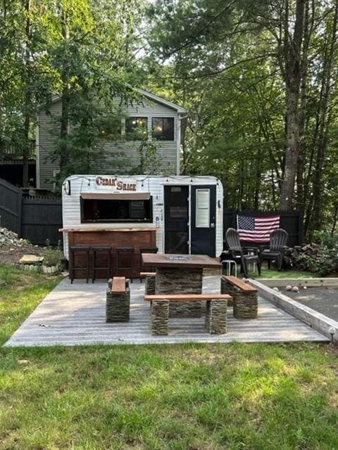 view of home's community with a yard, fence, and outdoor dry bar