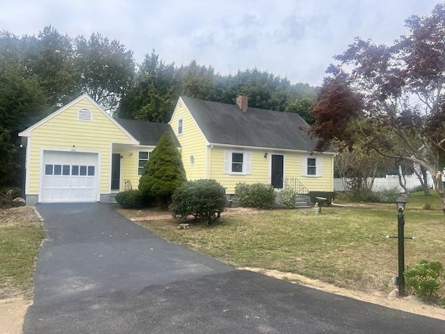 cape cod home with a front yard, driveway, a chimney, and an attached garage