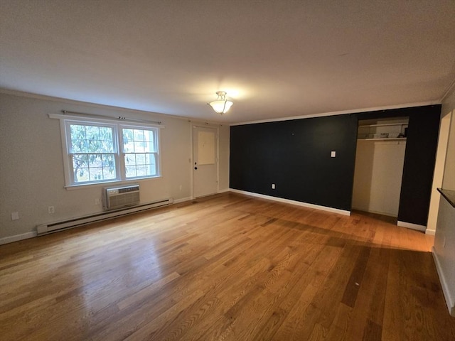 unfurnished room featuring wood-type flooring, ornamental molding, baseboard heating, and an AC wall unit