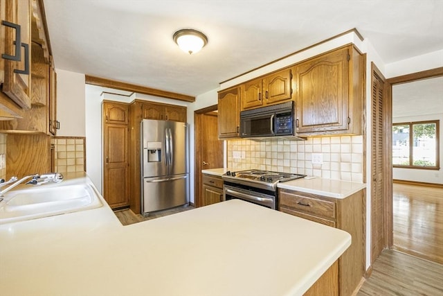 32 Arden St, Holyoke, MA 01040 - kitchen featuring stainless steel appliances, a sink, tasteful backsplash, and a peninsula