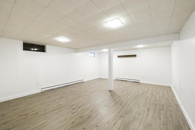 32 Arden St, Holyoke, MA 01040 - finished below grade area with a baseboard heating unit, wood finished floors, baseboards, and a drop ceiling