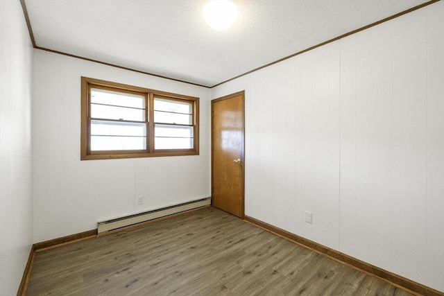 32 Arden St, Holyoke, MA 01040 - empty room featuring baseboard heating, wood finished floors, ornamental molding, and baseboards