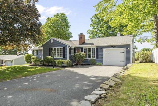 32 Arden St, Holyoke, MA 01040 - ranch-style house featuring asphalt driveway, a garage, a front yard, and a chimney